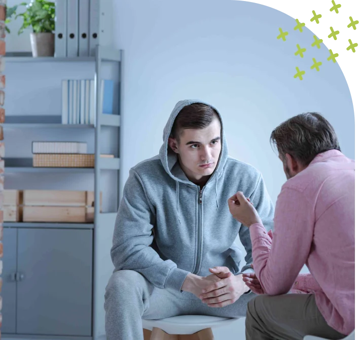 Teenager in counseling session talking with male therapist