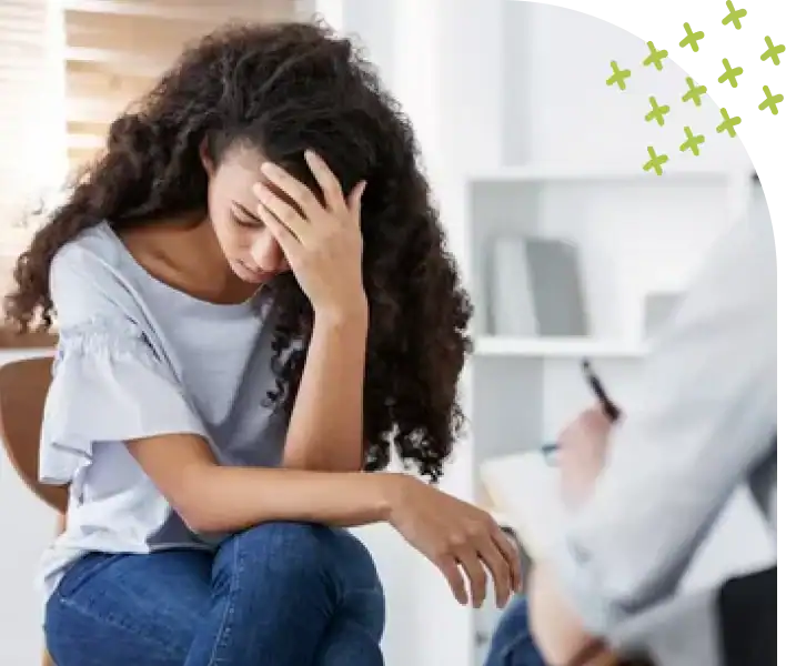 Stressed woman with head in hand during therapy session