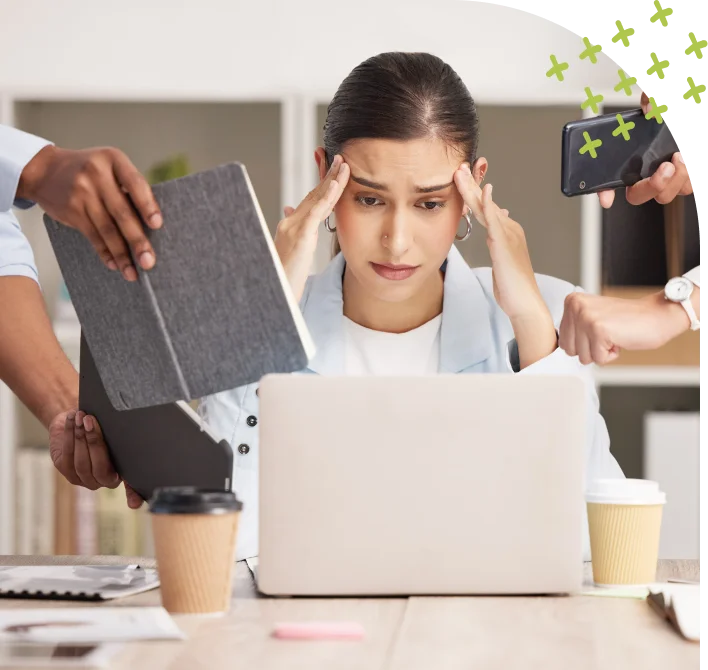 Stressed woman working on laptop surrounded by demands